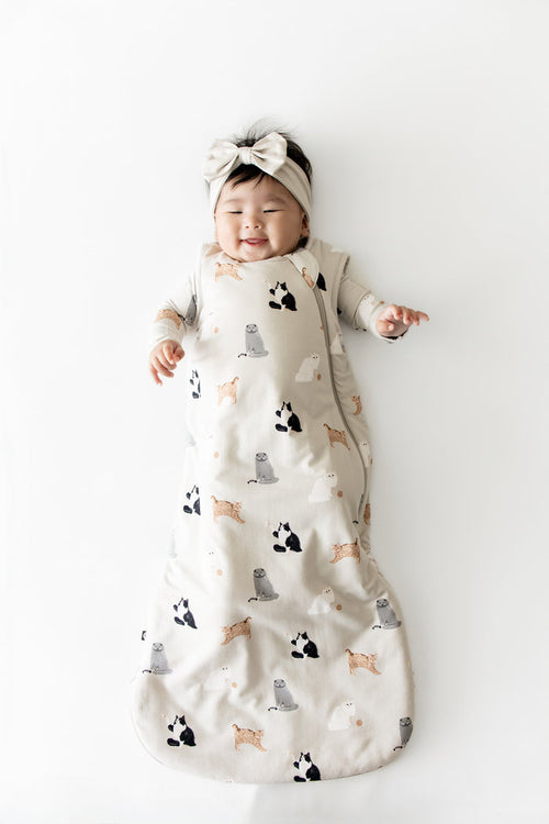 Smiling infant wearing he Sleep Bag in Fluffy Cat 1.0 with matching romper on underneath