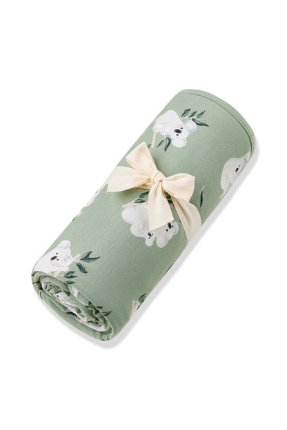 Swaddle Blanket in Koala rolled in its packaging tied with a linen bow