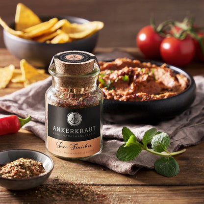 Ankerkraut Taco Gewürz im Korkenglas, vor einer Schale mit Dip und Nacho Chips.