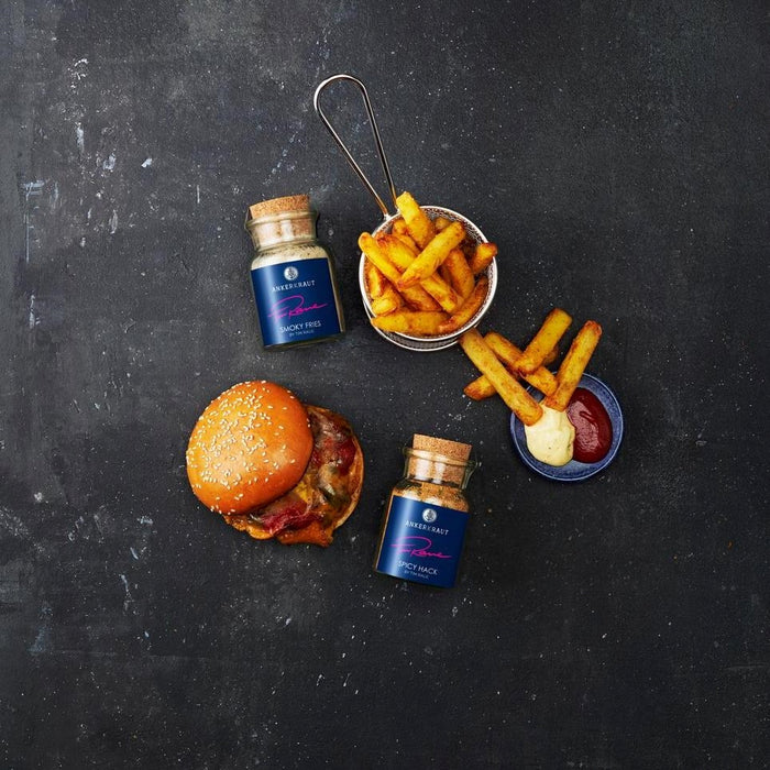 Ein saftiger Burger sowie knusprige Pommes aus der Vogelperspektive, daneben Ankerkraut Smoky Fries sowie Spicy Hack im Korkenglas.