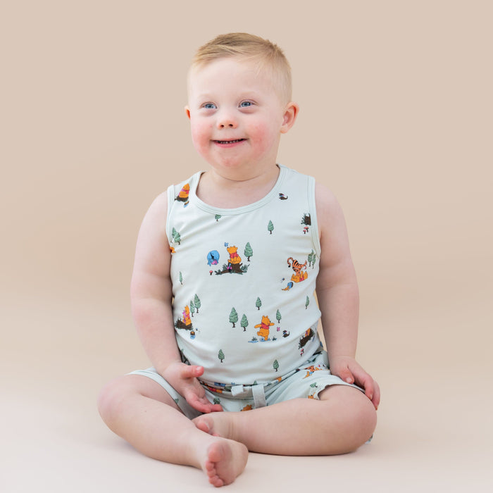 Young boy sitting on the floor wearing the Toddler Tank Top in Winnie the Pooh Hundred Acre Wood