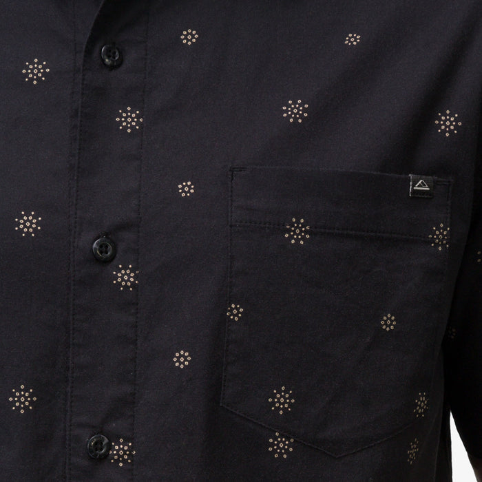 Close-up of the pocket and button area on the men's Topaz Shirt featuring subtle patterned dots on black fabric.