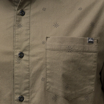Close-up of the olive green Topaz Shirt pocket with subtle dot pattern and black buttons, beach-inspired comfort apparel.