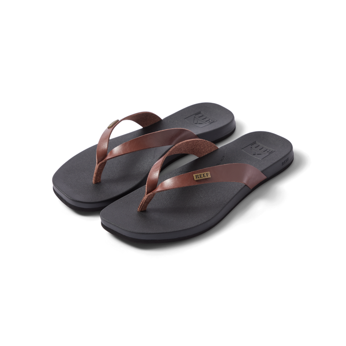 Vista Lune women's flip flops facing right, close-up of brown straps and cushioned black footbed, beach-inspired comfort design.