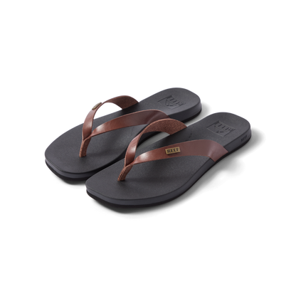 Vista Lune women's flip flops facing right, close-up of brown straps and cushioned black footbed, beach-inspired comfort design.
