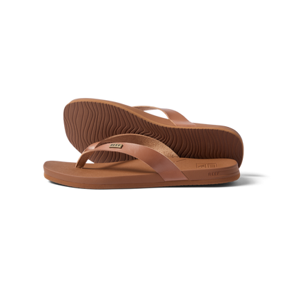 Vista Lune women's tan flip flops facing right, close-up on sole and strap, beach-inspired comfort and arch support sandals.