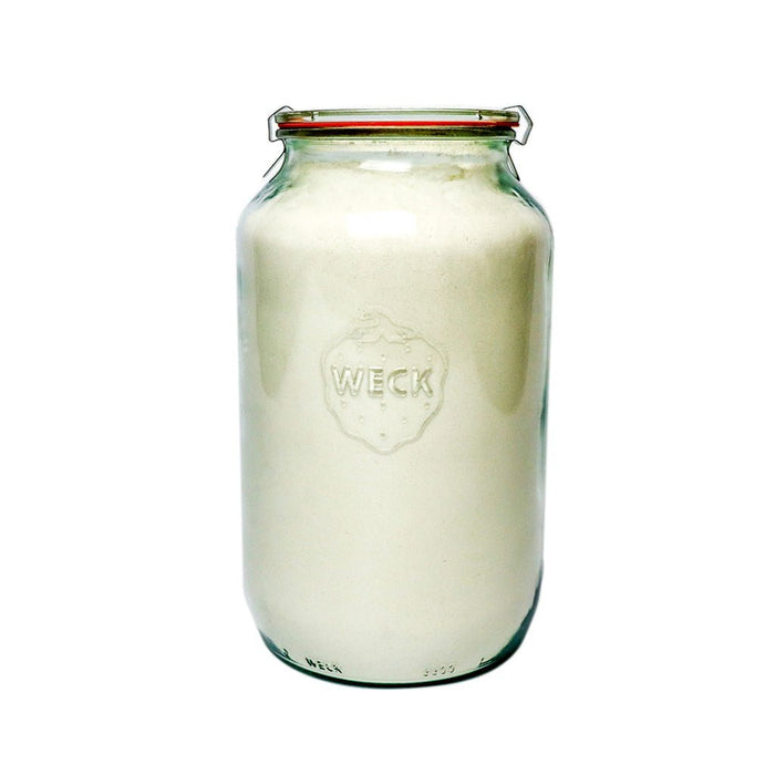 Glass Weck barrel jar filled with flour on white background