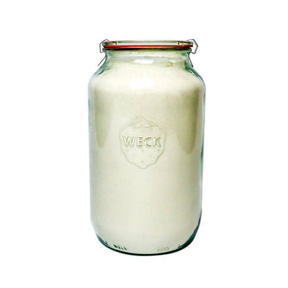 Glass Weck barrel jar filled with flour on white background