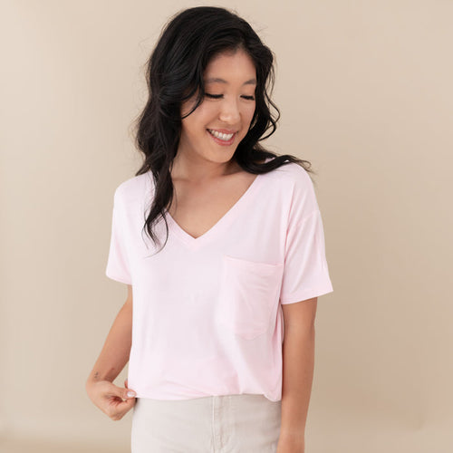 Woman modeling Women’s Relaxed Fit V-Neck in Sakura against a tan backdrop