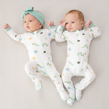 Two infants lying side by side both wearing the Zippered Footie in The Very Hungry Caterpillar™ and Friends
