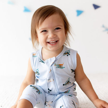 Close up of smiling toddler wearing the Zippered Sleeveless Romper in Take Off